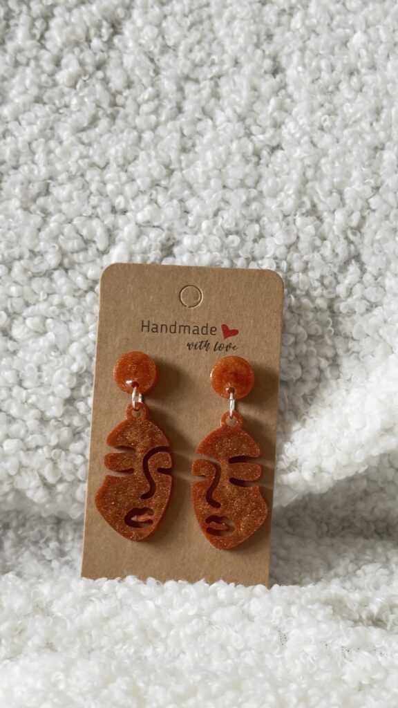Boucles d'oreilles en forme de visage de femme surmonté par un rond au niveau de l'attache