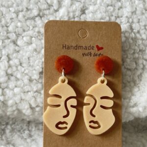 Boucles d'oreilles en forme de visage de femme surmonté par un rond au niveau de l'attache
