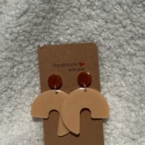 Paire de boucles d'oreilles en résine époxy en forme de 3/4 de rond surmontées d'un rond au niveau de l'attache, attachées à un carton fait main